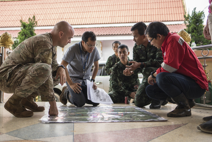 Airmen from the U.S. Indo-Pacific Command (USINDOPACOM) meet with Royal Thai military officials and a Thai engineering company to advise and assist in the rescue operation June 30, 2018, at Chiang Rai, Thailand. The United States, through USINDOPACOM, sent a search and rescue team to Tham Luang cave in Northern Thailand at the request of the Royal Thai government to assist in the rescue of the missing Thai soccer players and their coach. Image taken from the website of the DoD, and is used here under fair use law. Image taken from the website of the DoD, and is used here under fair use law.