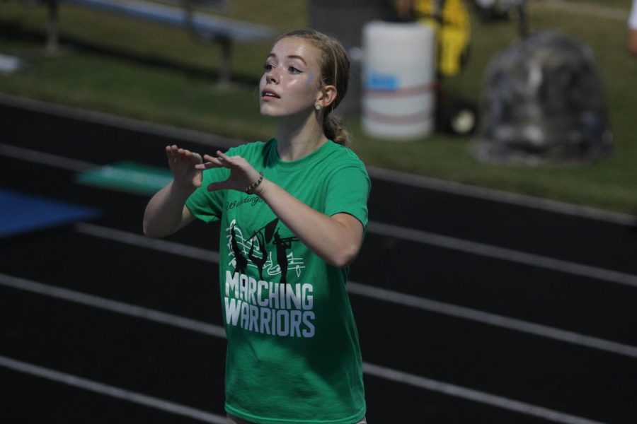 Drum Major Kaitlyn Dirr directs the Marching Warriors as they help cheer on the Weddington High School football team.